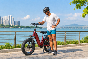 Rider checking the display of a red Heybike folding electric bike before a waterfront ride