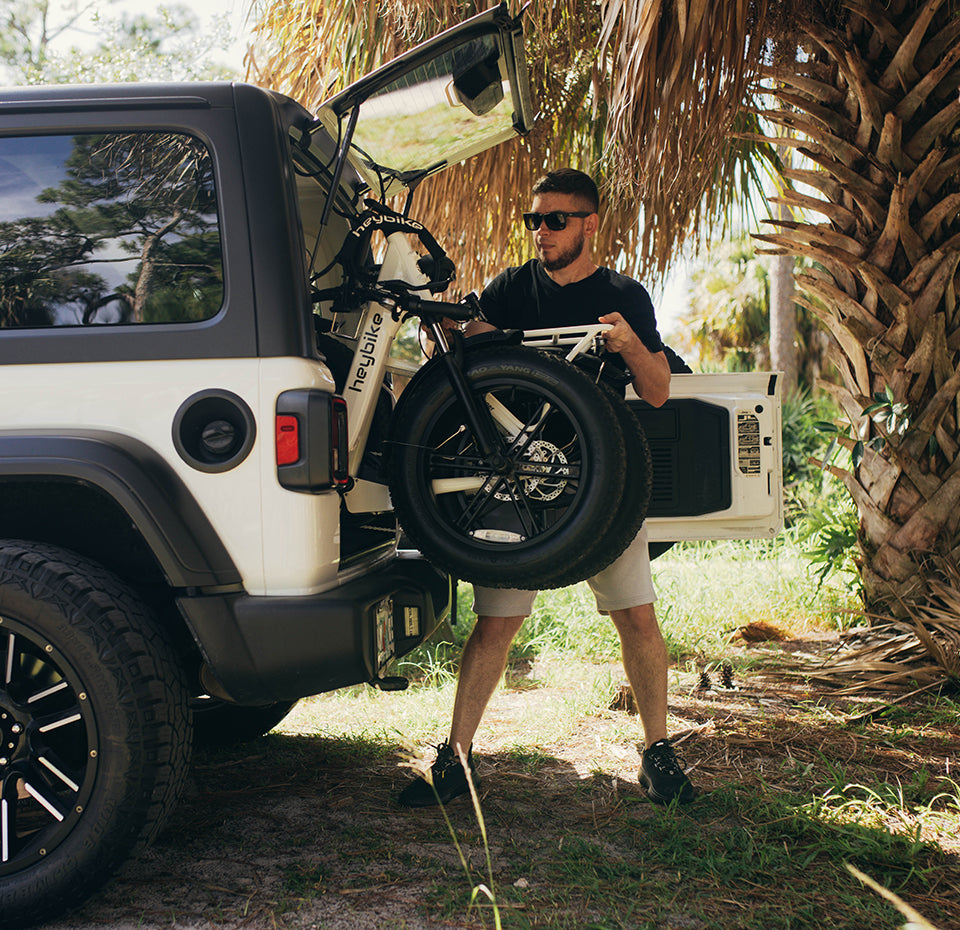 A man folds his Heybike ranger ebike and easyly loads it into an RV trunk