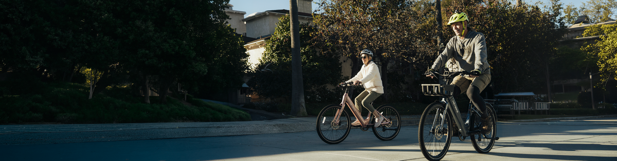 Heybike cruiser bikes ridden by two people on a city street