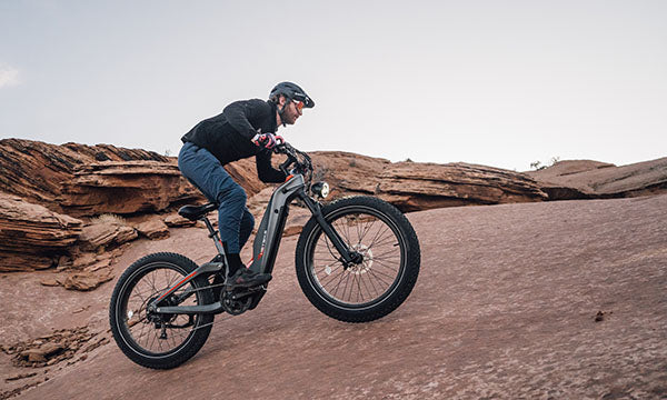 a man riding Hero mid-drive ebike uphill