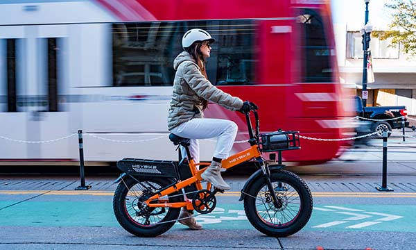 A woman is riding the Mars 2.0 folding e-bike on the city road