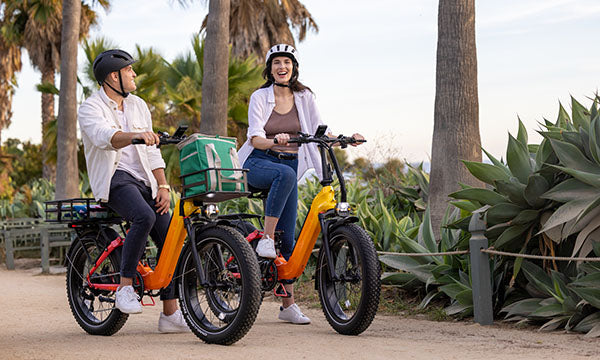 A man and a girl are riding a Horizon fat tire bike in the spring season