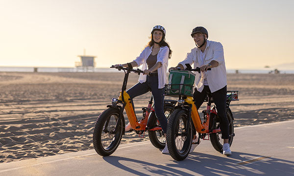 A man and girl are riding Horizon fat tire ebike on beach