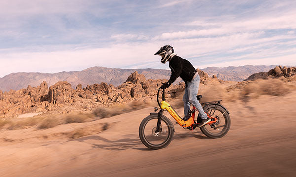 A man is riding a Horizon full-suspension e-bike outside