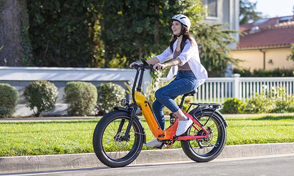 A girl is wearing a helmet while riding a Heybike Horizon e-bike on the road