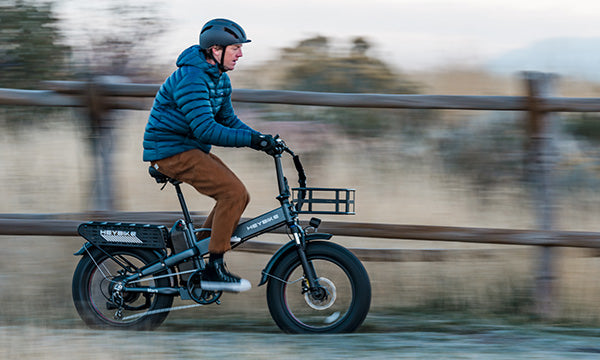 A man is riding a Mars 2.0 folding fat tire e-bike, moving quickly