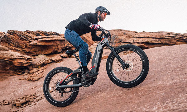 a man is riding Hero eMTB uphill by mid-drive motor 