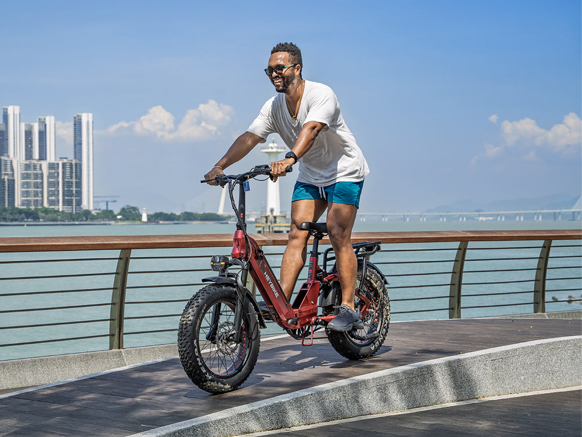 Rider on a red Heybike Ranger 3.0 Pro folding fat-tire electric bike along a waterfront path