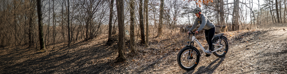 Man riding a Heybike Alpha mid-drive ebike through a forest